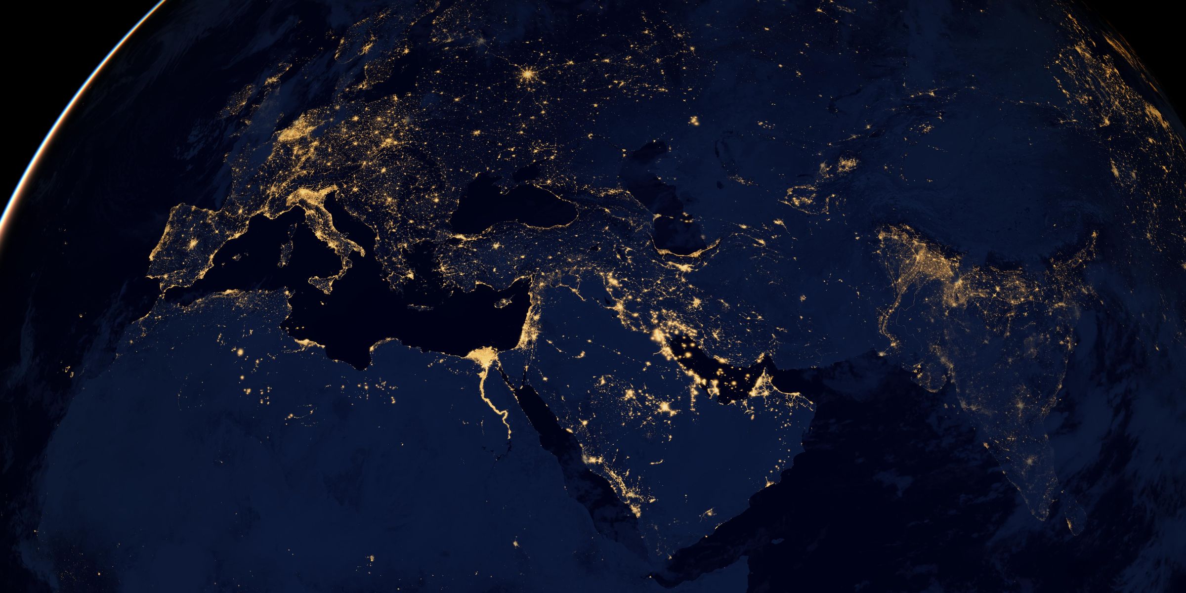 Night-time satellite view of Earth showing Europe, North Africa and the Middle East, with city lights tracing the Mediterranean coast, the Nile valley and the Persian Gulf.